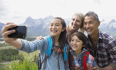 Family taking cell phone picture on rural hillside