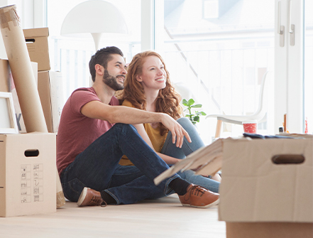 Young couple in new flat with cardboard boxes