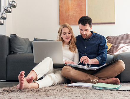 Couple with laptop looking at paperwork.