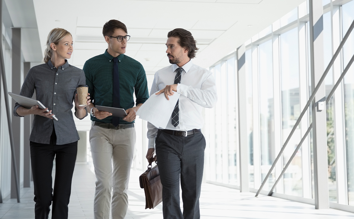 Business people walking in office corridor.