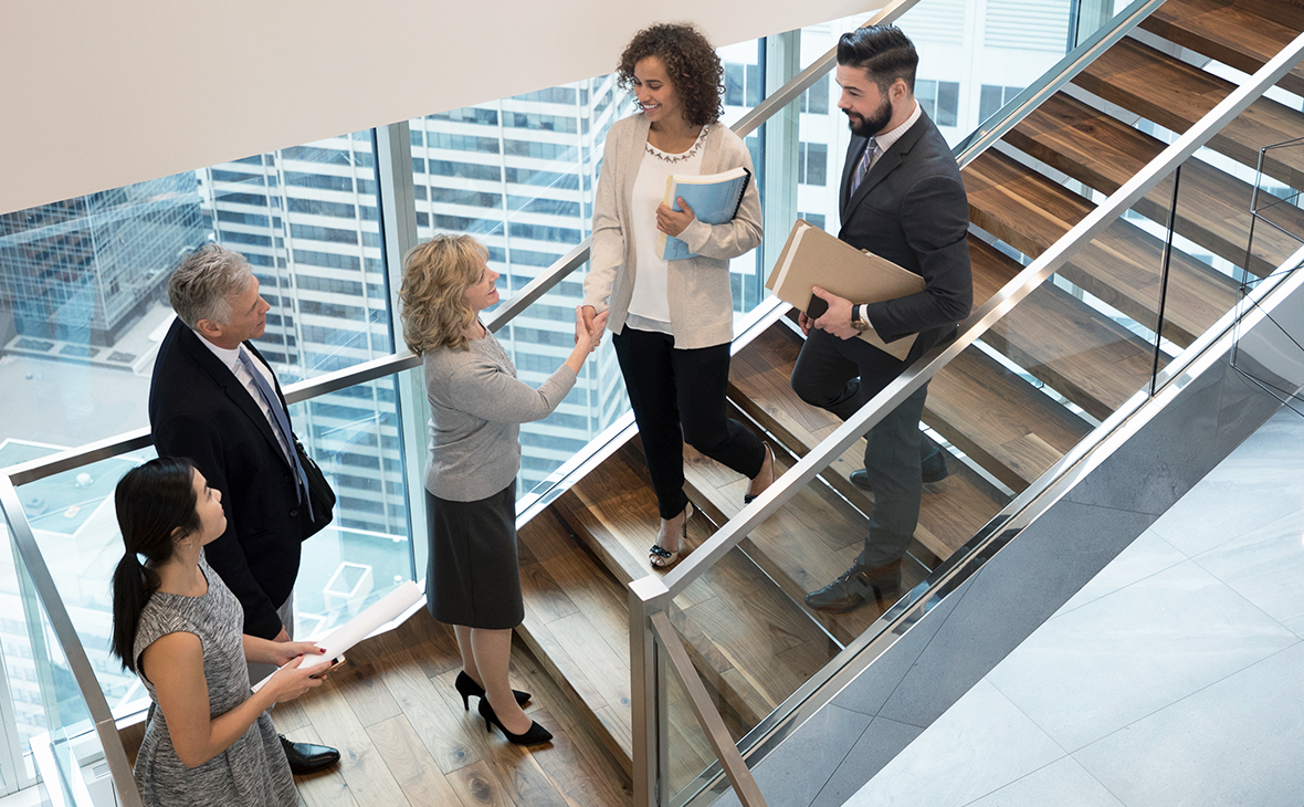 Business people handshaking on modern, urban office staircase