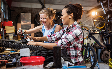 Two women fixing bicycle's in their workshop