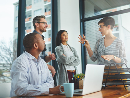 A group of people attends a meeting in a business conference room.