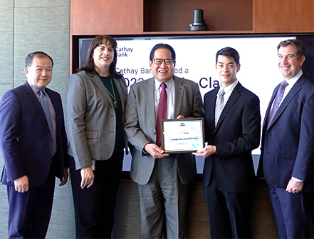 Team Members from Cathay Bank pose with the Gallagher Award and members from the firm in a conference room.