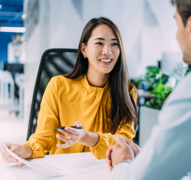 Shot of confident businesswoman filling in paperwork in an office. Business persons signing a document during a meeting in board room.