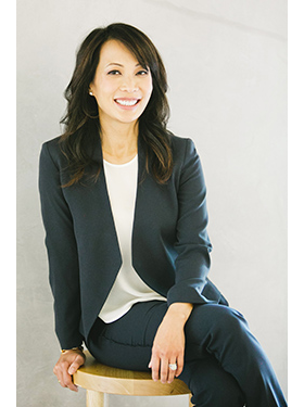 身穿蓝色西装和白色衬衫的高管女商人Ann Kono 在专业工作室中微笑着摆姿势拍摄公司头像。