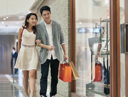 Happy couple window shopping in luxury mall