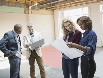 Business people reviewing blueprint in new office