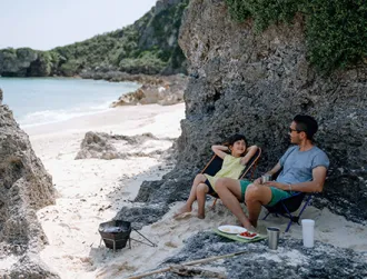 Father and young daughter having fun at beach campsite