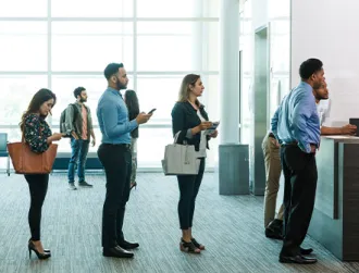 Bank customers form a line to see a bank teller and learn more about special rates. 