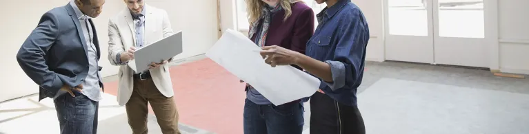 Business people reviewing blueprint in new office