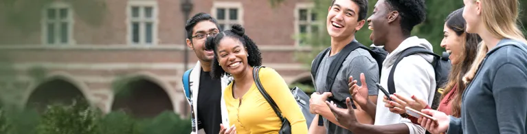 A group of students chatting happily while walking in the campus.