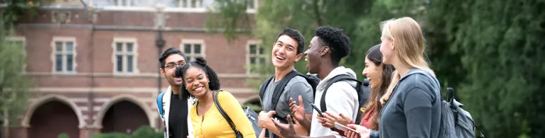 A group of students chatting happily while walking in the campus.