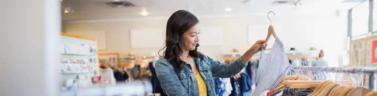 Woman eyeing shirt in clothing shop