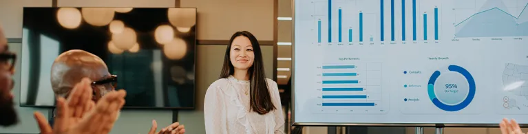 A young woman presents asset-based lending options to a meeting room full of people.