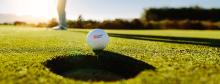 A golf ball with Cathay Bank logo sits outdoors on grass for the annual tournament in California.