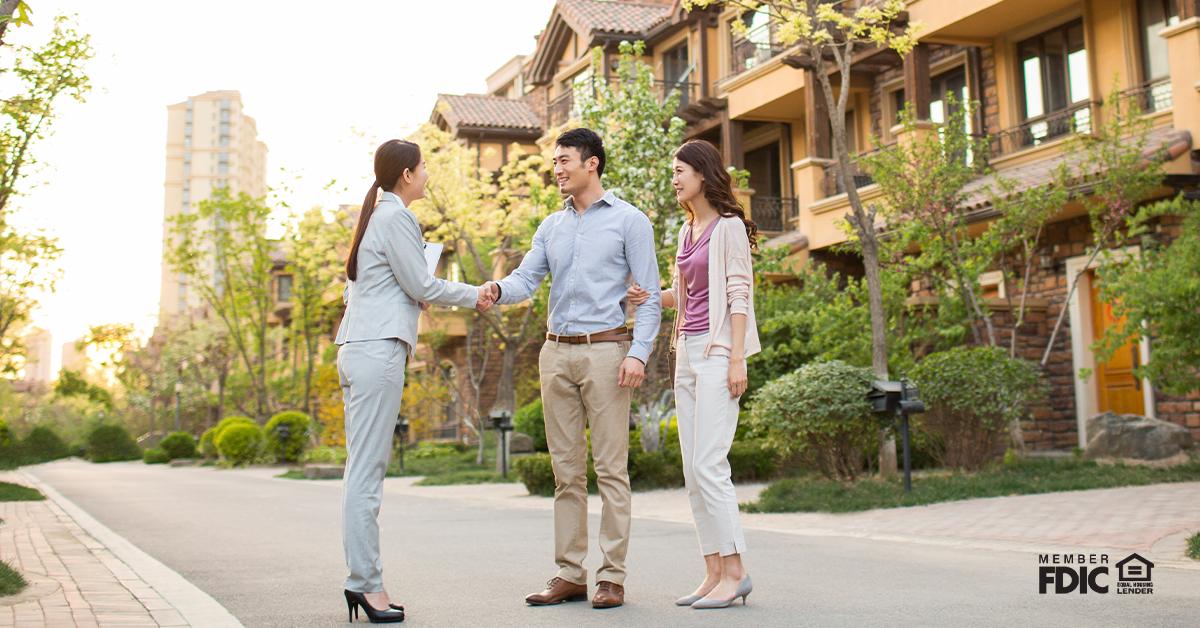 Happy young couple shaking hands with realtor
