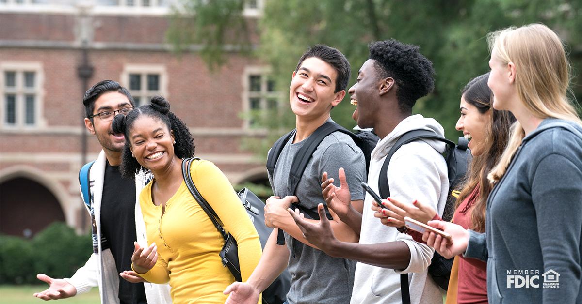 A group of students chatting happily while walking in the campus.