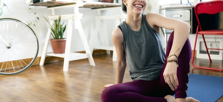 Happy young woman practicing yoga at home