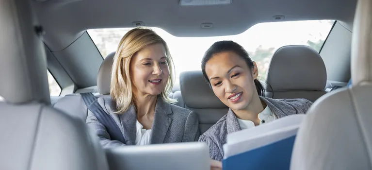 Business colleagues reviewing paperwork in car