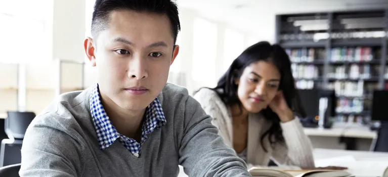 Student using laptop in college library