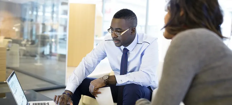 Business people working at laptop in office lobby