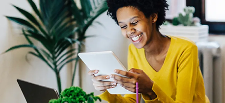 Young woman sitting at table with several portable device.