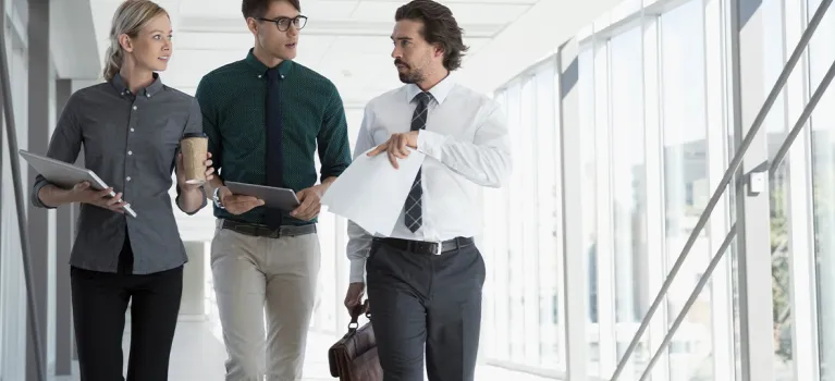 Business people walking in office corridor.