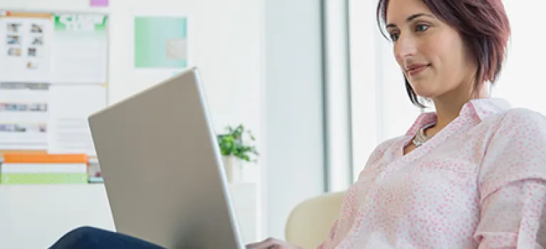 Businesswoman working at laptop in office.