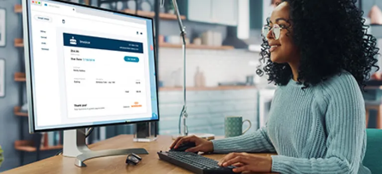 A businesswoman using her Autobooks service to email an invoice to her client.