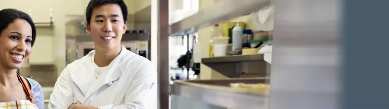 Smiling bakers standing in bakery