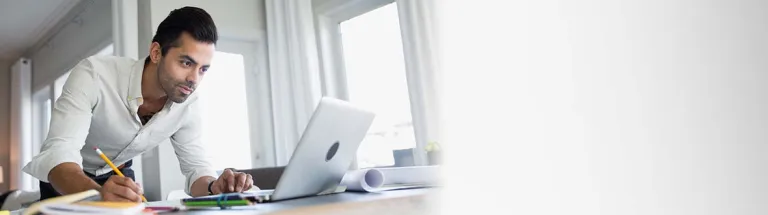 Architect working at laptop on dining table