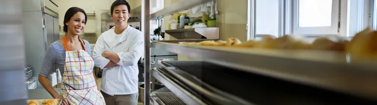 Smiling bakers standing in bakery
