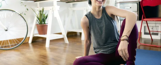 Happy young woman practicing yoga at home