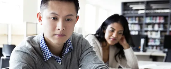 Student using laptop in college library