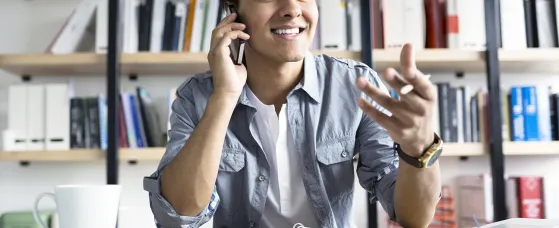 Young businessman talking on cell phone in office