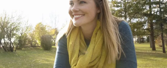 Smiling woman with bicycle looking away in sunny park