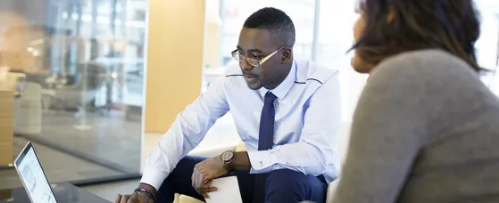 Business people working at laptop in office lobby