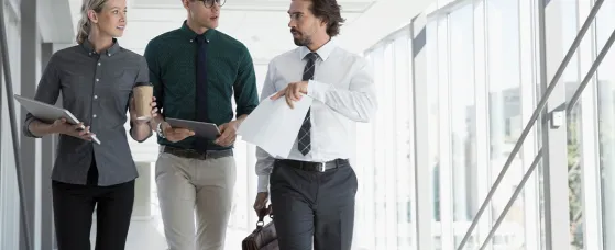 Business people walking in office corridor.