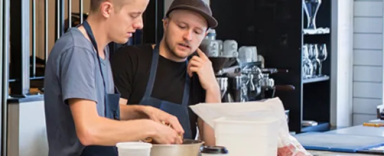Chefs talking in restaurant kitchen