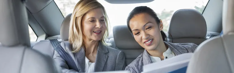 Business colleagues reviewing paperwork in car