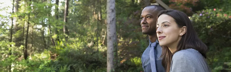 Couple drinking on cabin balcony in woods