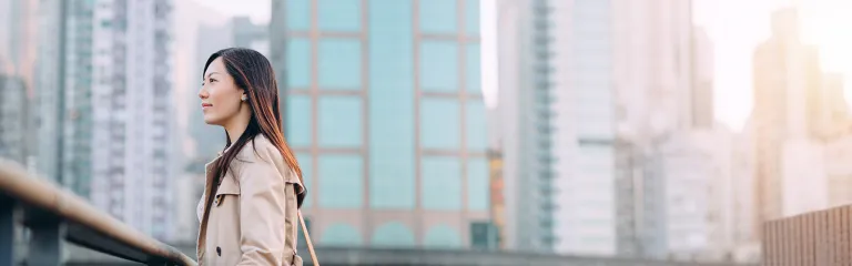 A young woman against commercial cityscape on a fresh morning