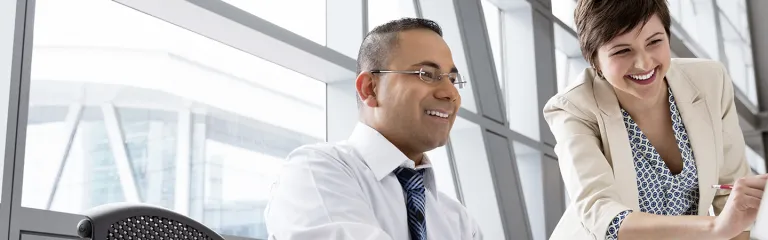 Businesswoman showing project on computer monitor in office building