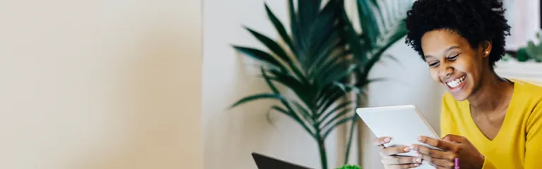 Young woman sitting at table with several portable device.