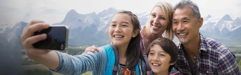 Family taking cell phone picture on rural hillside