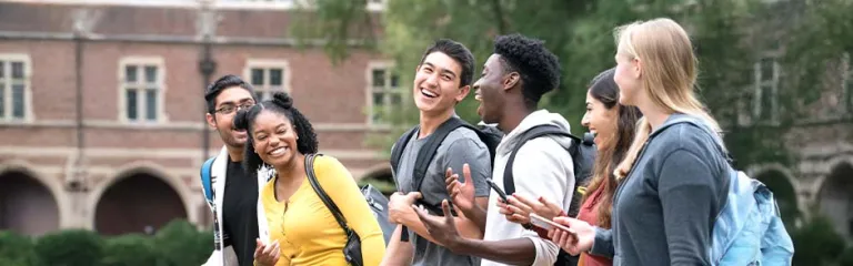 A group of students chatting happily while walking in the campus